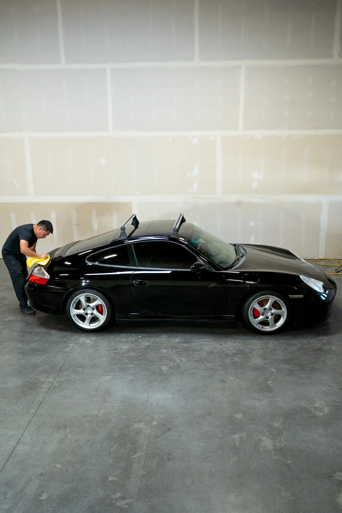 A black Porsche 911 waiting in the Diamond Coating Auto Studio bay
