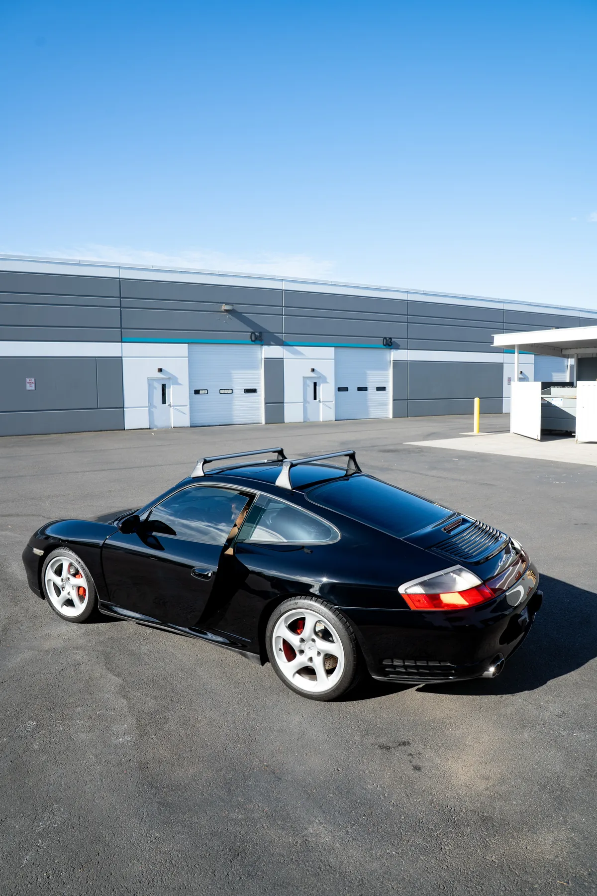 A black Porsche 911 outside the studio on a clear day