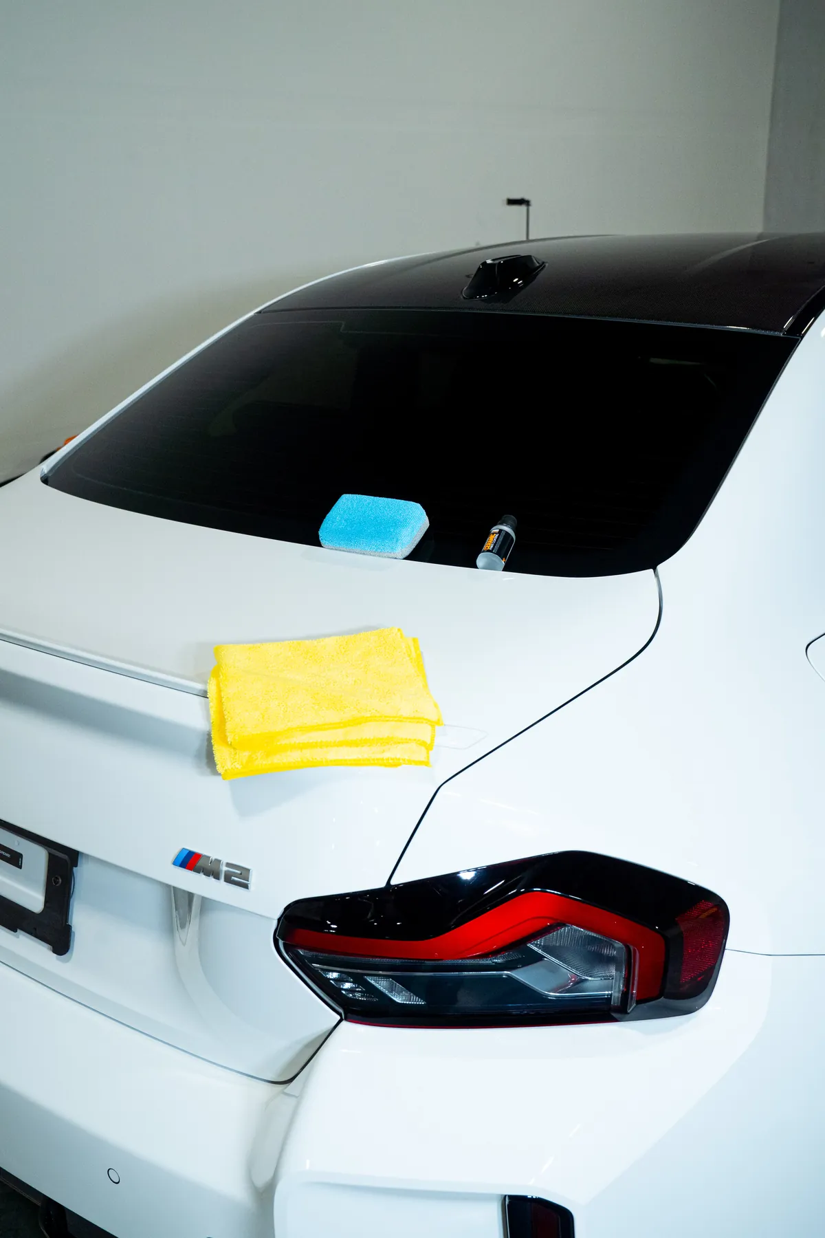 The rear quarter of a white BMW M2 after a coating