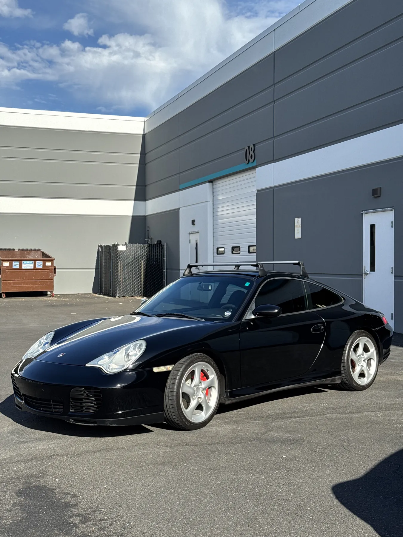 A black Porsche 996 Turbo parked outside the studio unit