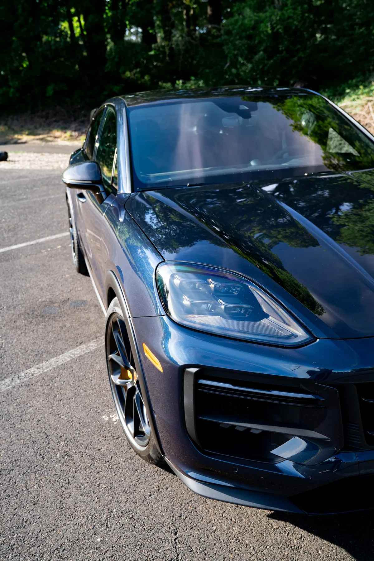 A blue Porsche Cayenne Turbo GT parked outside after a detail